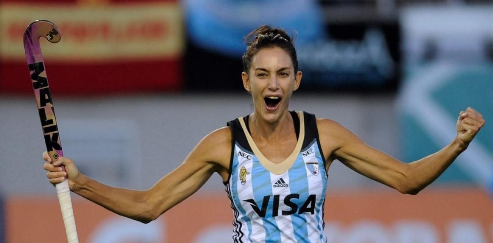 Mujer con palo de Hockey y remera rayada.