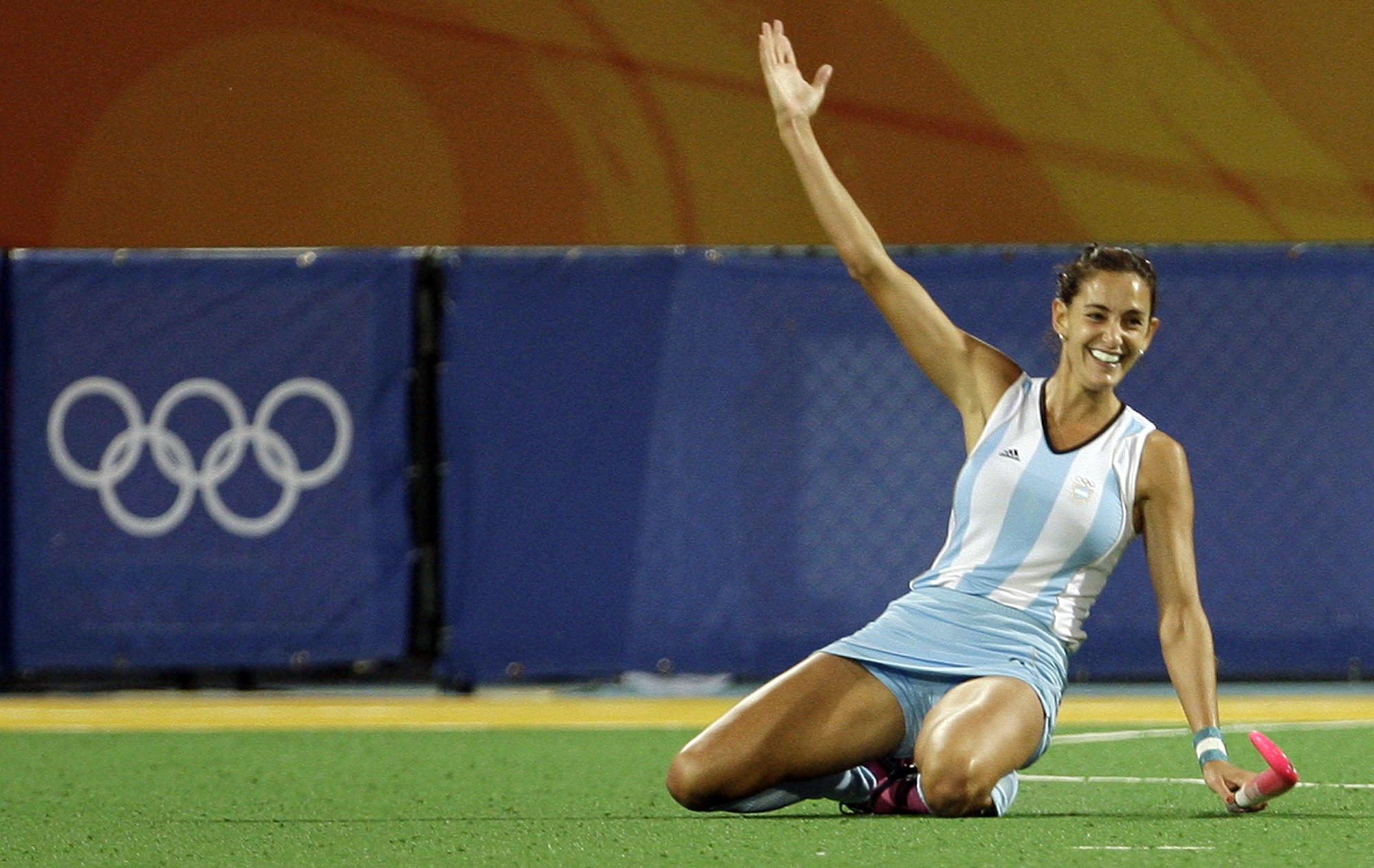 Mujer en el suelo con el brazo levantado.