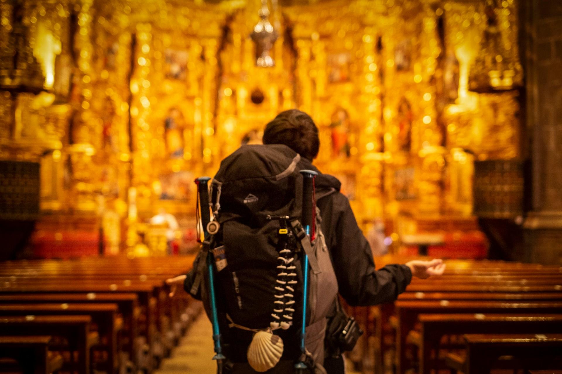 Hombre con mochila dentro de una iglesia.