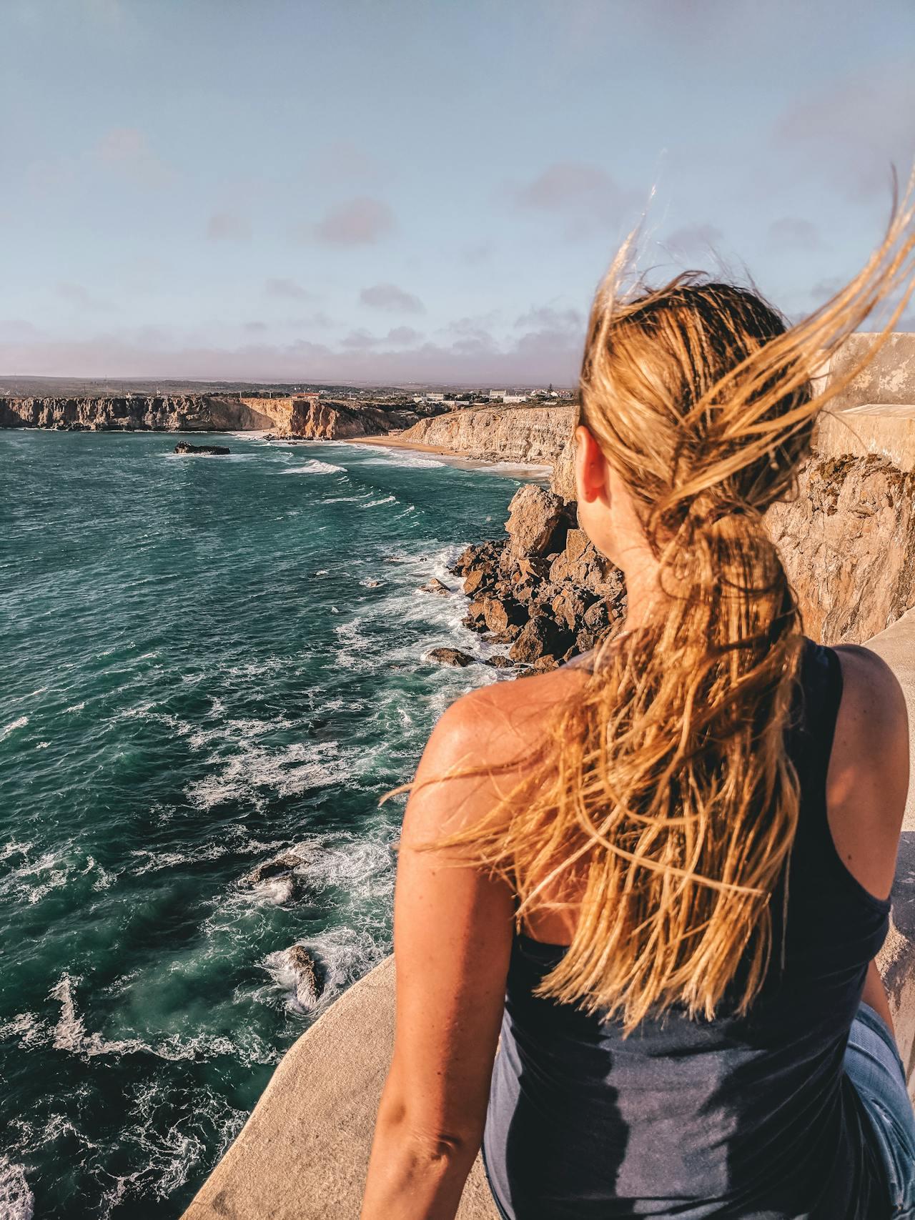 Mujer de espaldas mirando al mar.