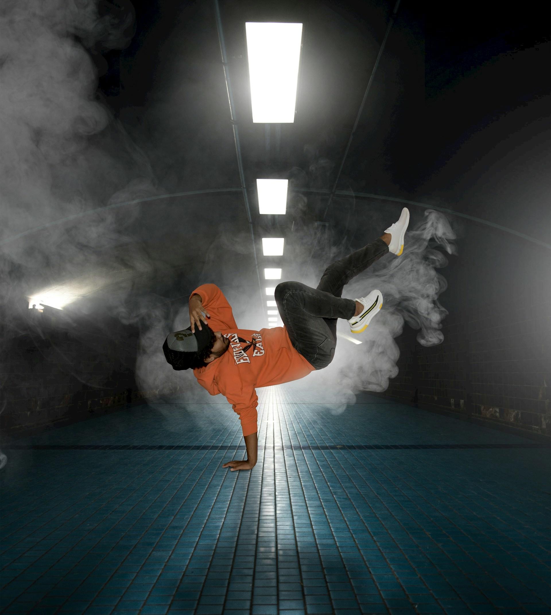 Hombre con buzo naranja bailando.