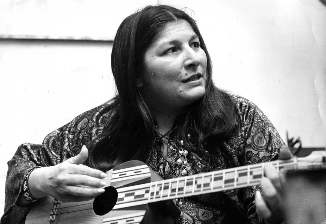 Mujer mirando al costado con una guitarra. Foto de Mercedes Sosa.