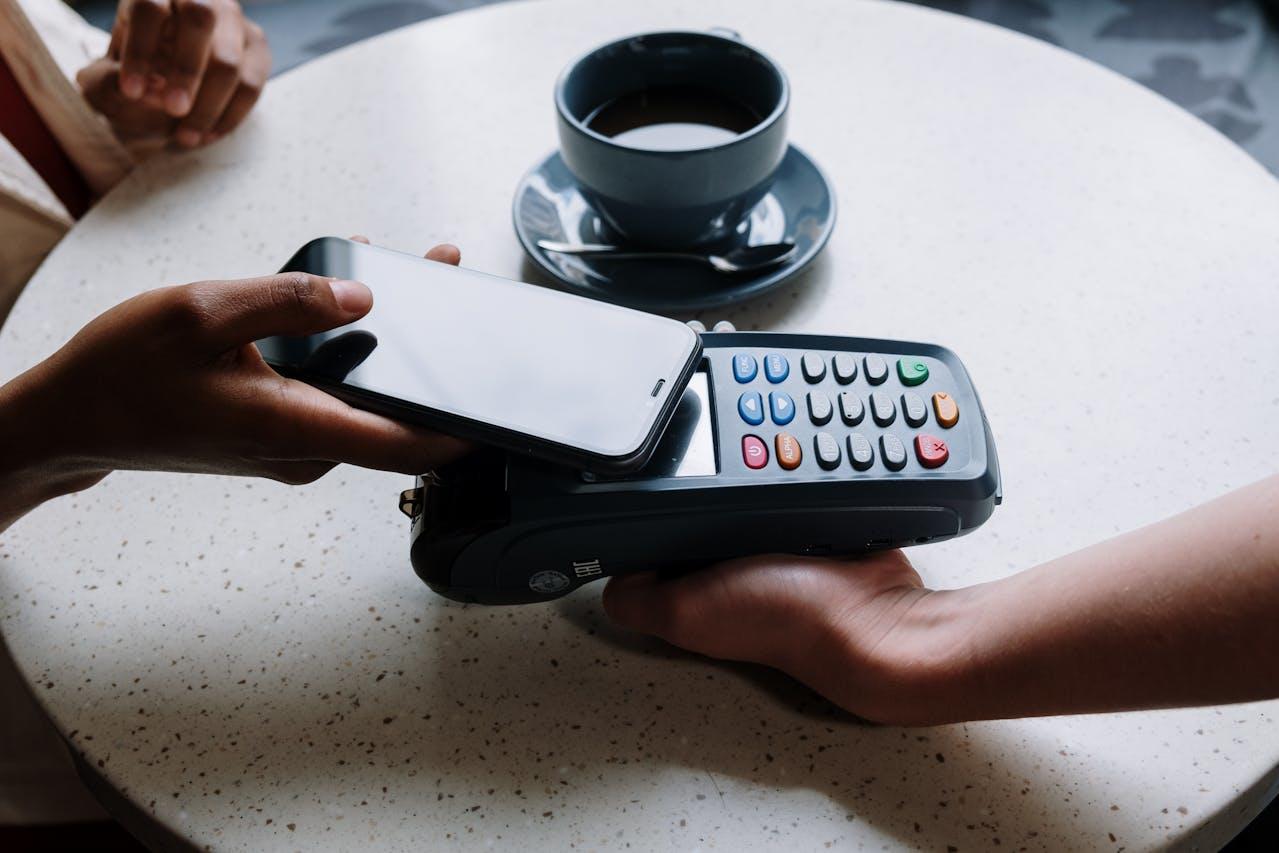 Celular sobre el postnet y taza de café.