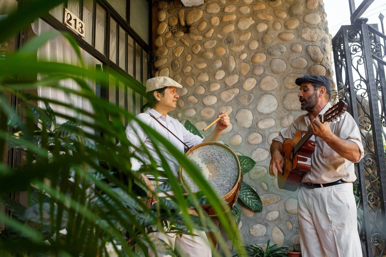 Dos hombres parados con instrumentos musicales.