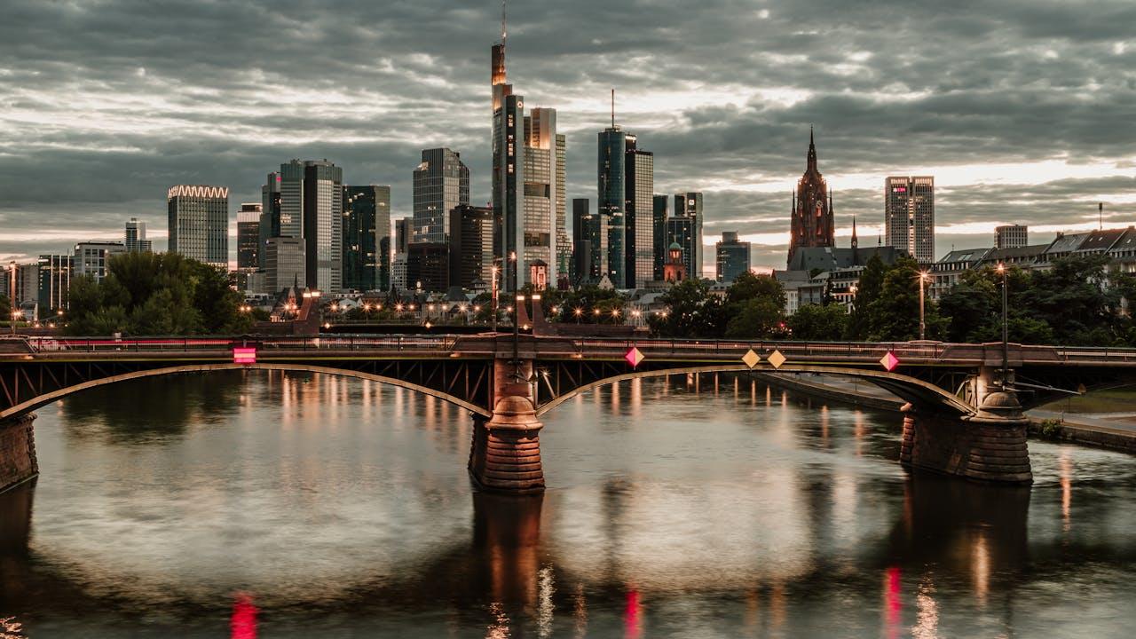 Rascacielos y puente sobre el río con cielo gris.