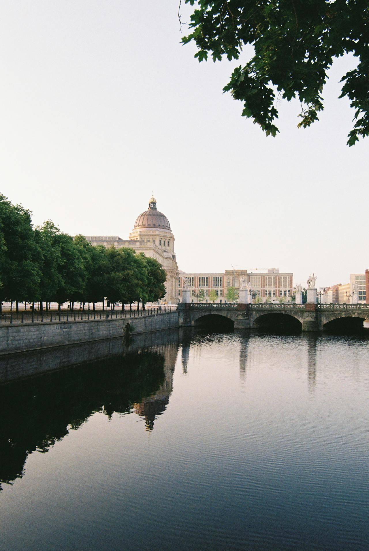 Río con puente y edificio con cúpula de fondo.