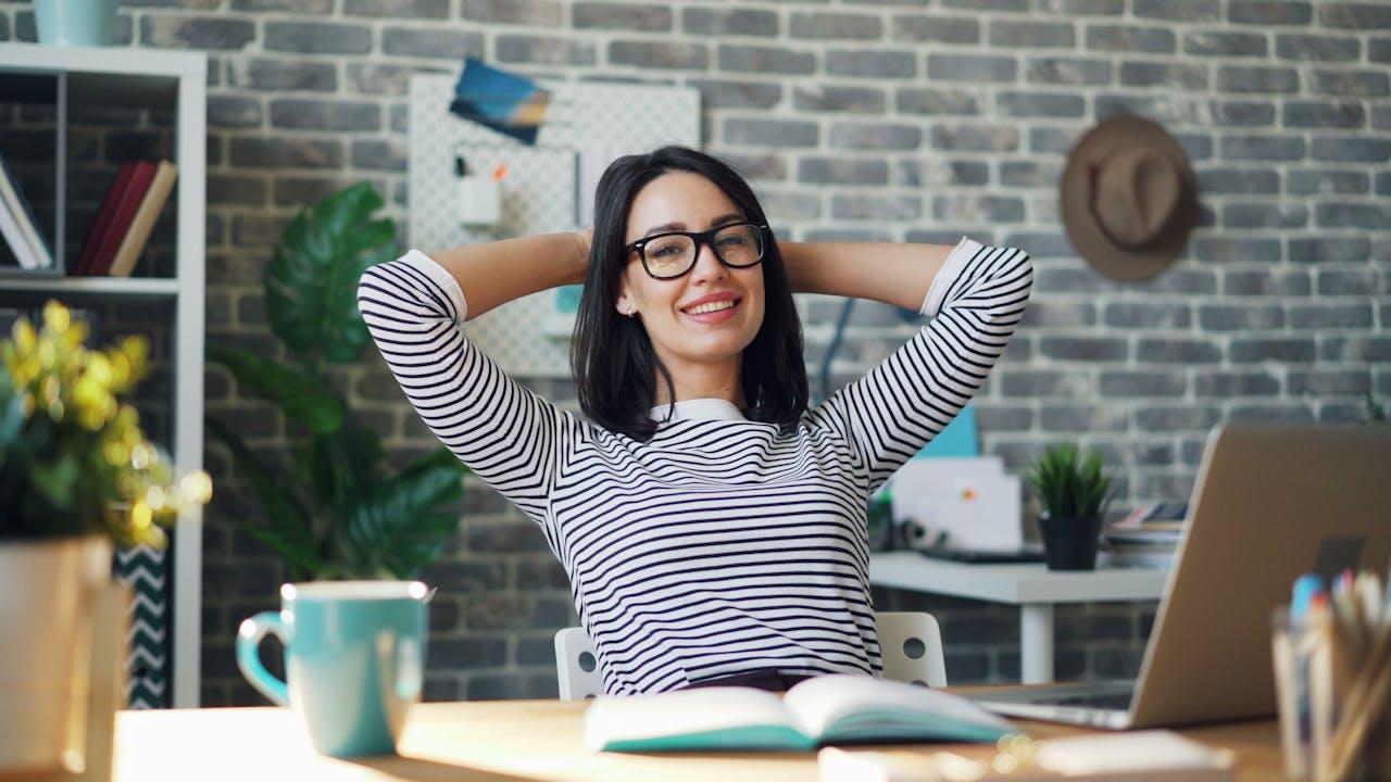 Mujer sonriendo sentada frente la pc.
