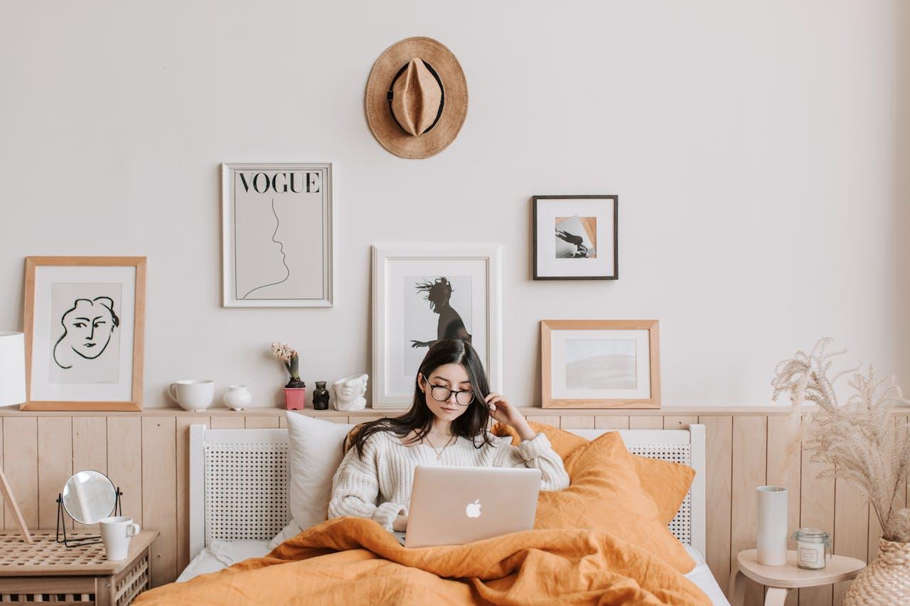 Mujer en la cama mirando el ordenador.