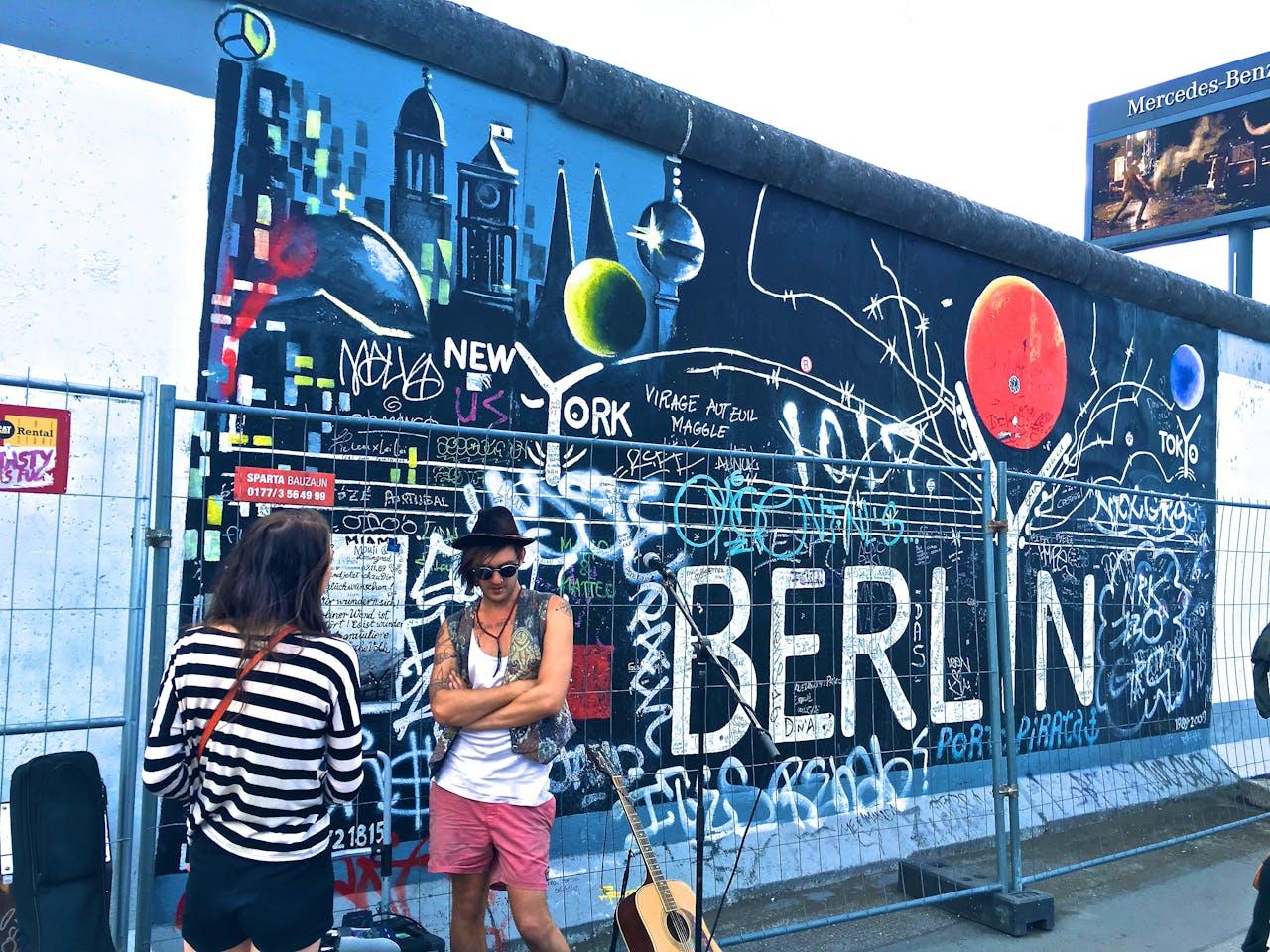Mural con grafitis y personas adelante.