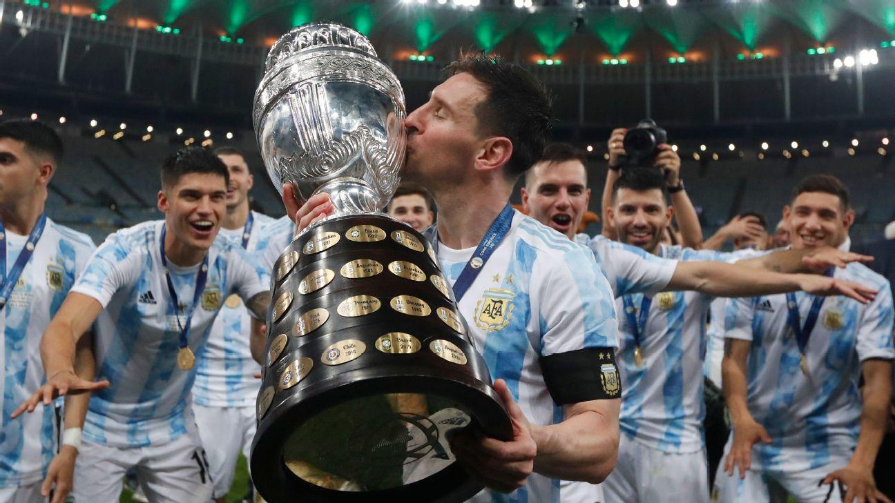 Jugadores con camiseta celeste y blanca besando copa.