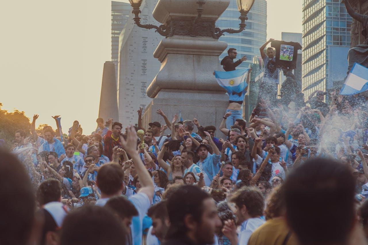Personas festejando en la calle con banderas.
