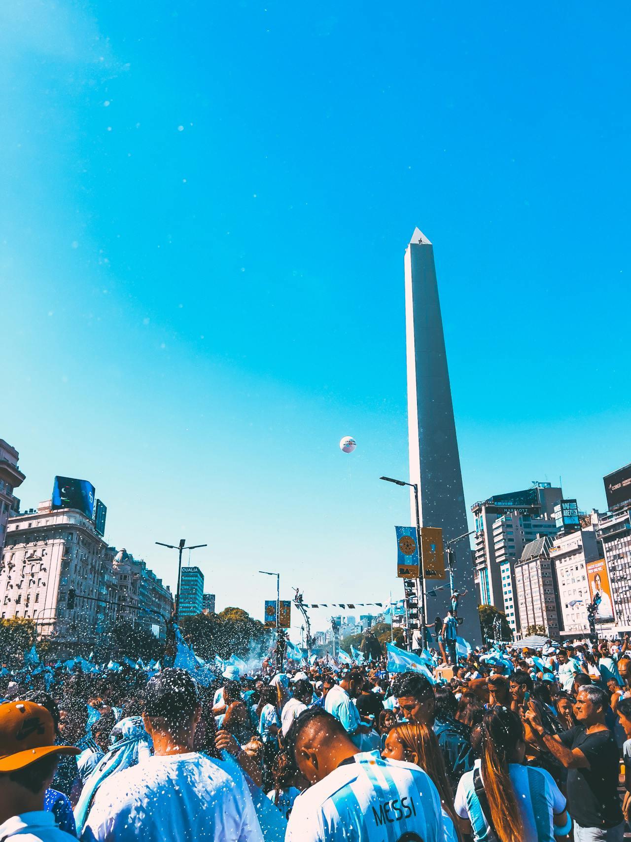 Mucha gente con banderas y remeras celestes y blancas.