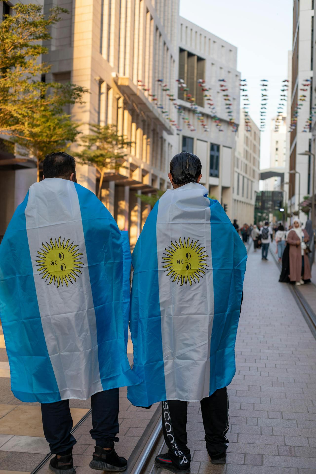 Dos personas de espada con bandera celeste y blanca.