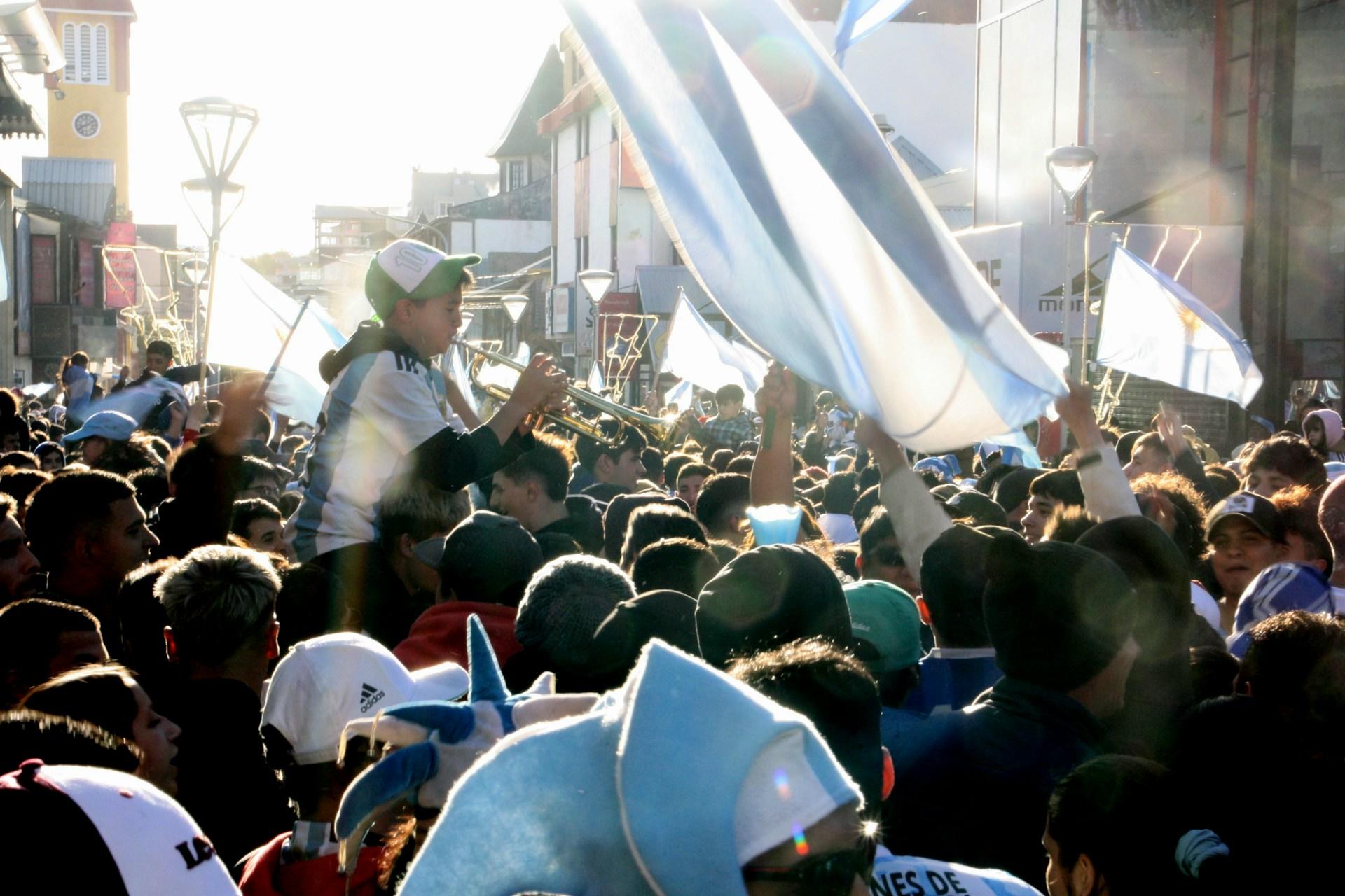 Muchedumbre en la calle con banderas.