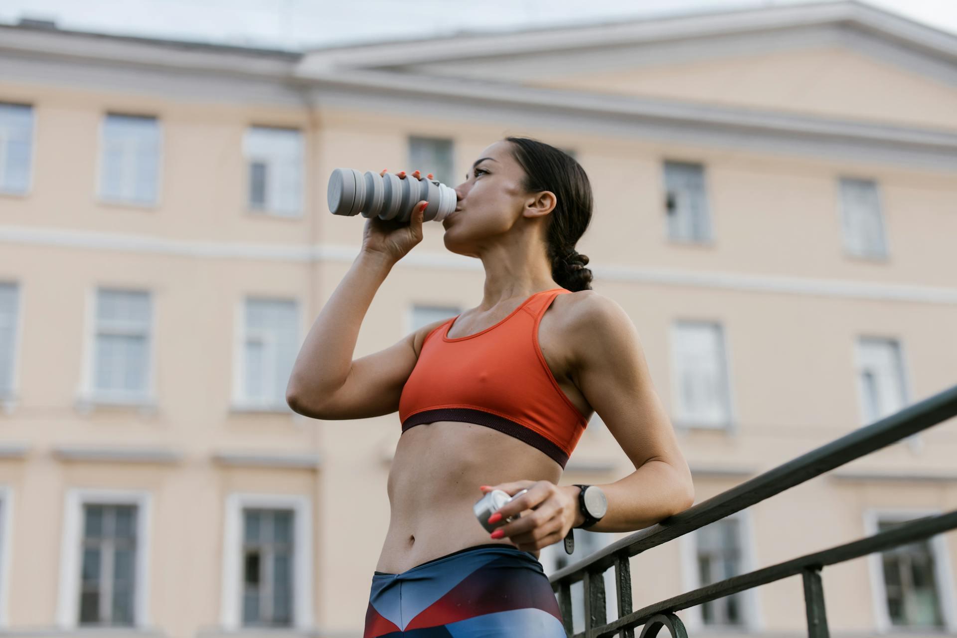 Mujer tomando agua de una botella.