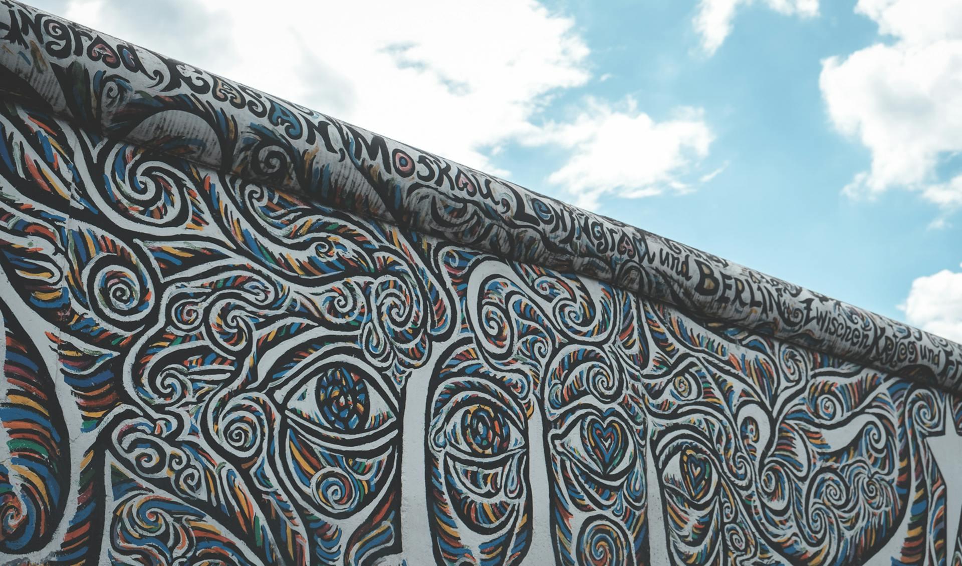 Muro con grafitis bajo cielo celeste.