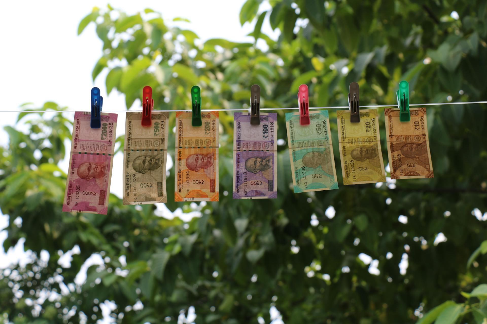 Billetes de colores abrochados en una cuerda blanca.