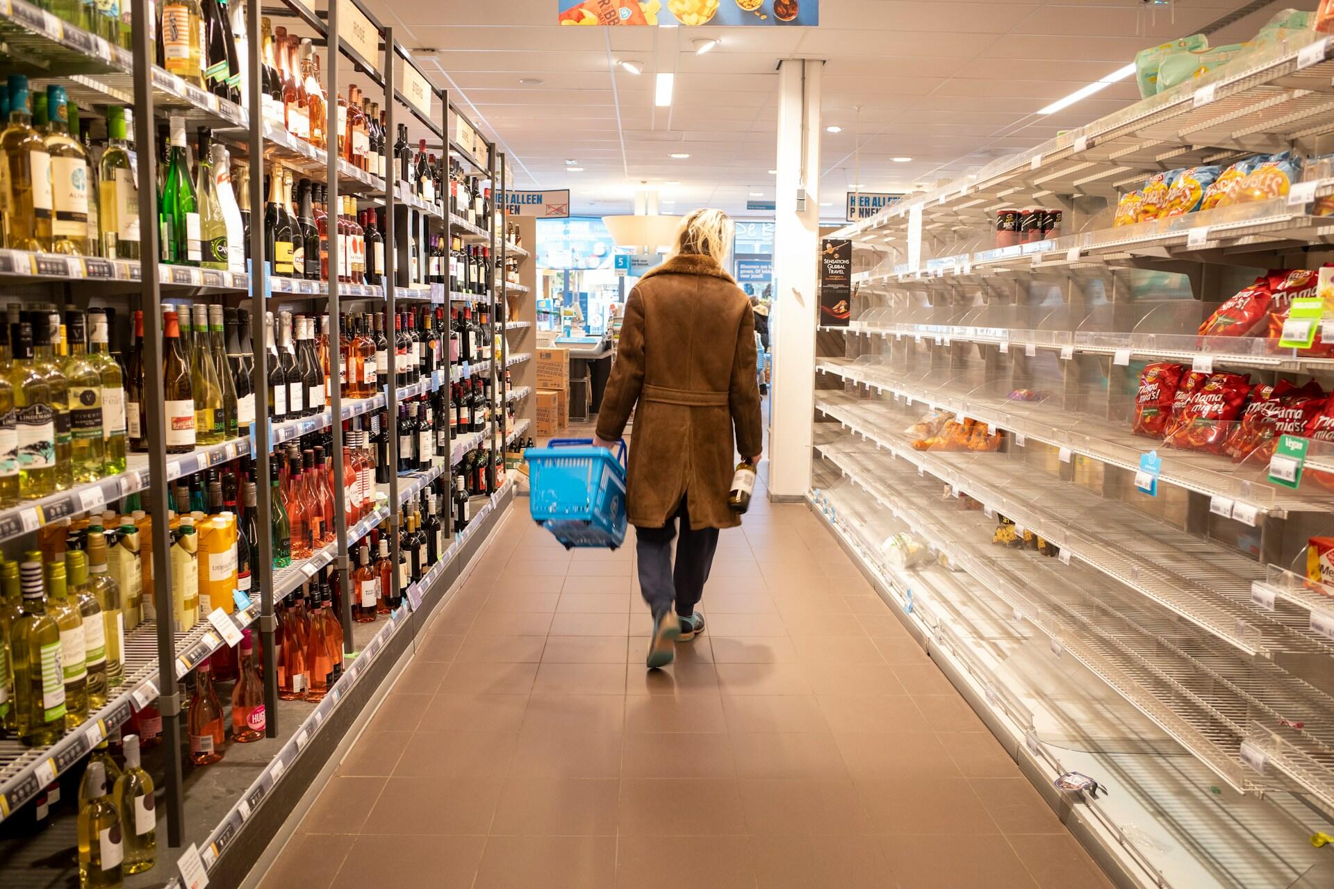 Persona caminando por la góndola del supermercado.
