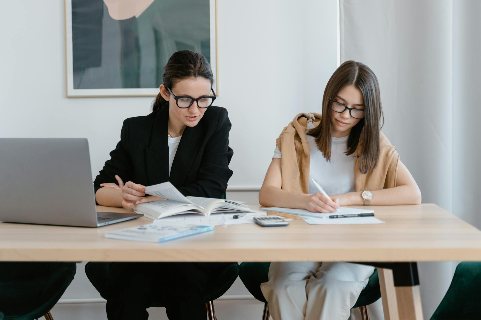 Dos mujeres sentadas en el escritorio.