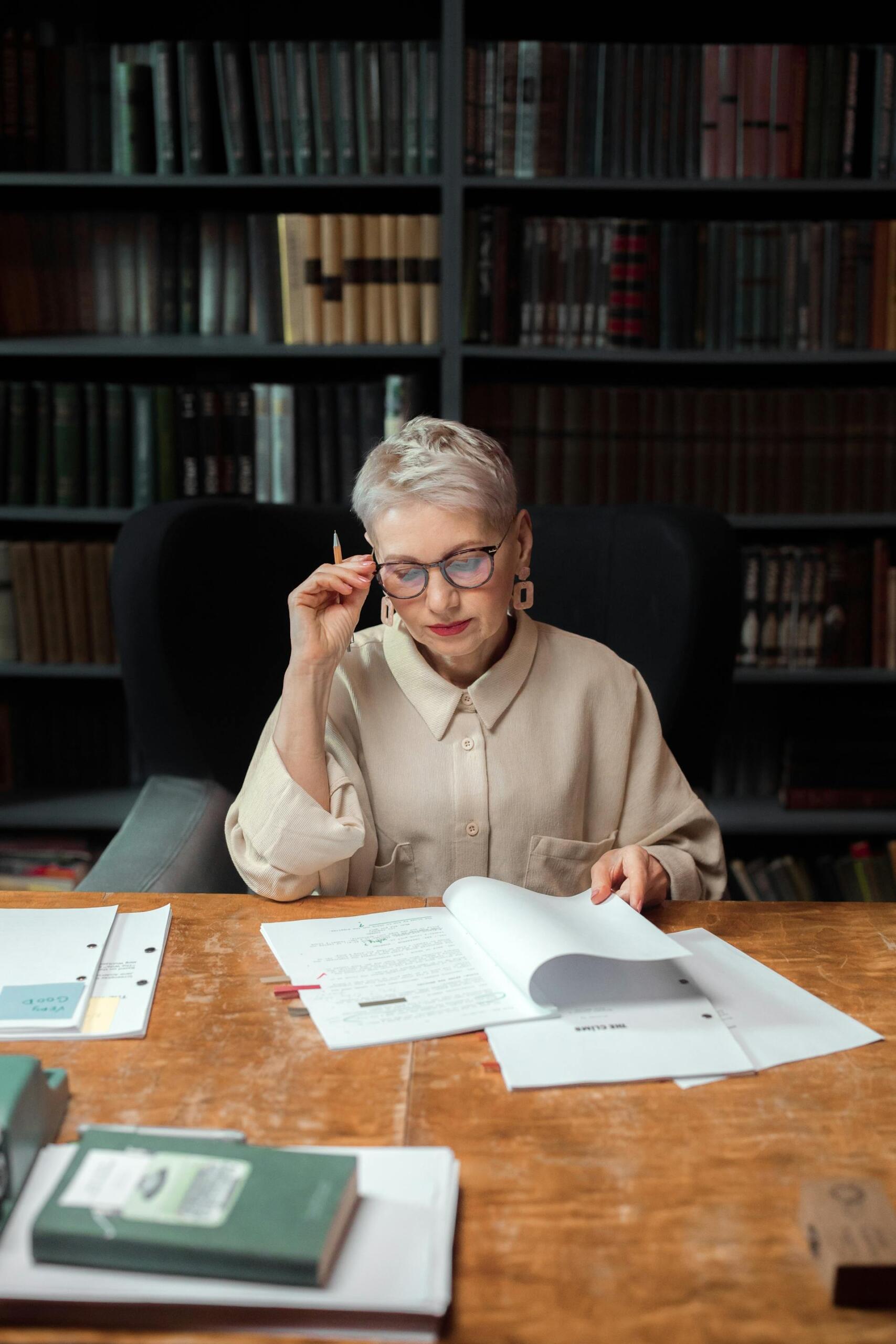 Mujer leyendo sentada en el escritorio.