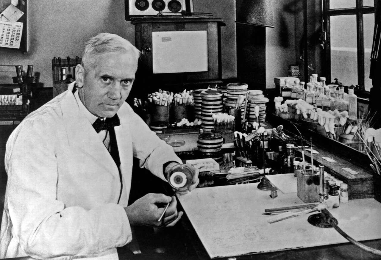 Hombre con delantal blanco sentado en el laboratorio.