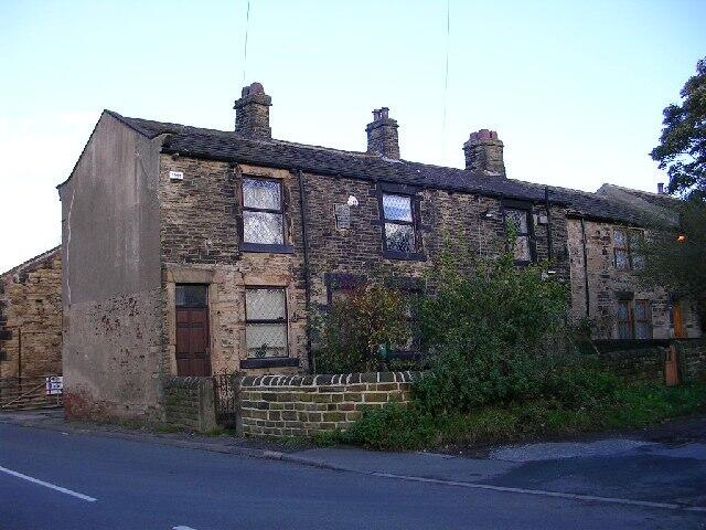 Casa de ladrillo al costado de la calle de asfalto.