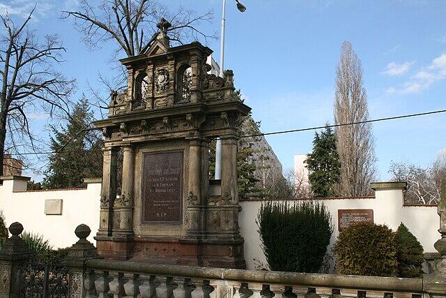 Mausoleo de cemento con columnas y placa.