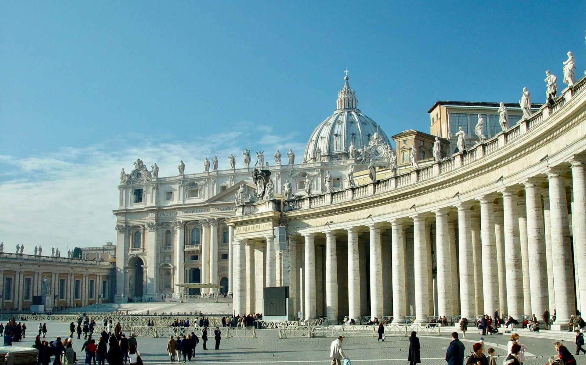 Edificios de piedra blancos con columnas, cúpulas y estatuas.