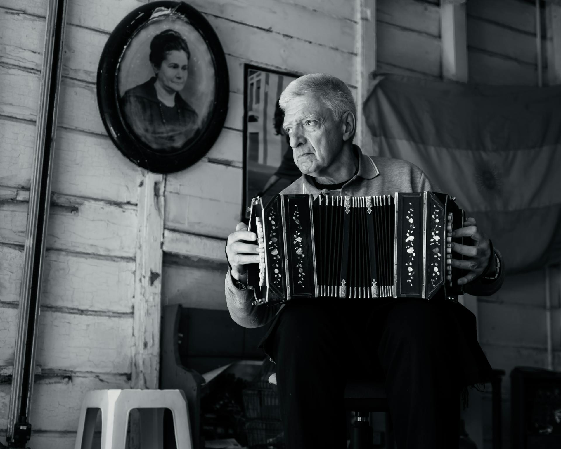 Hombre sentado tocando el bandoneón.