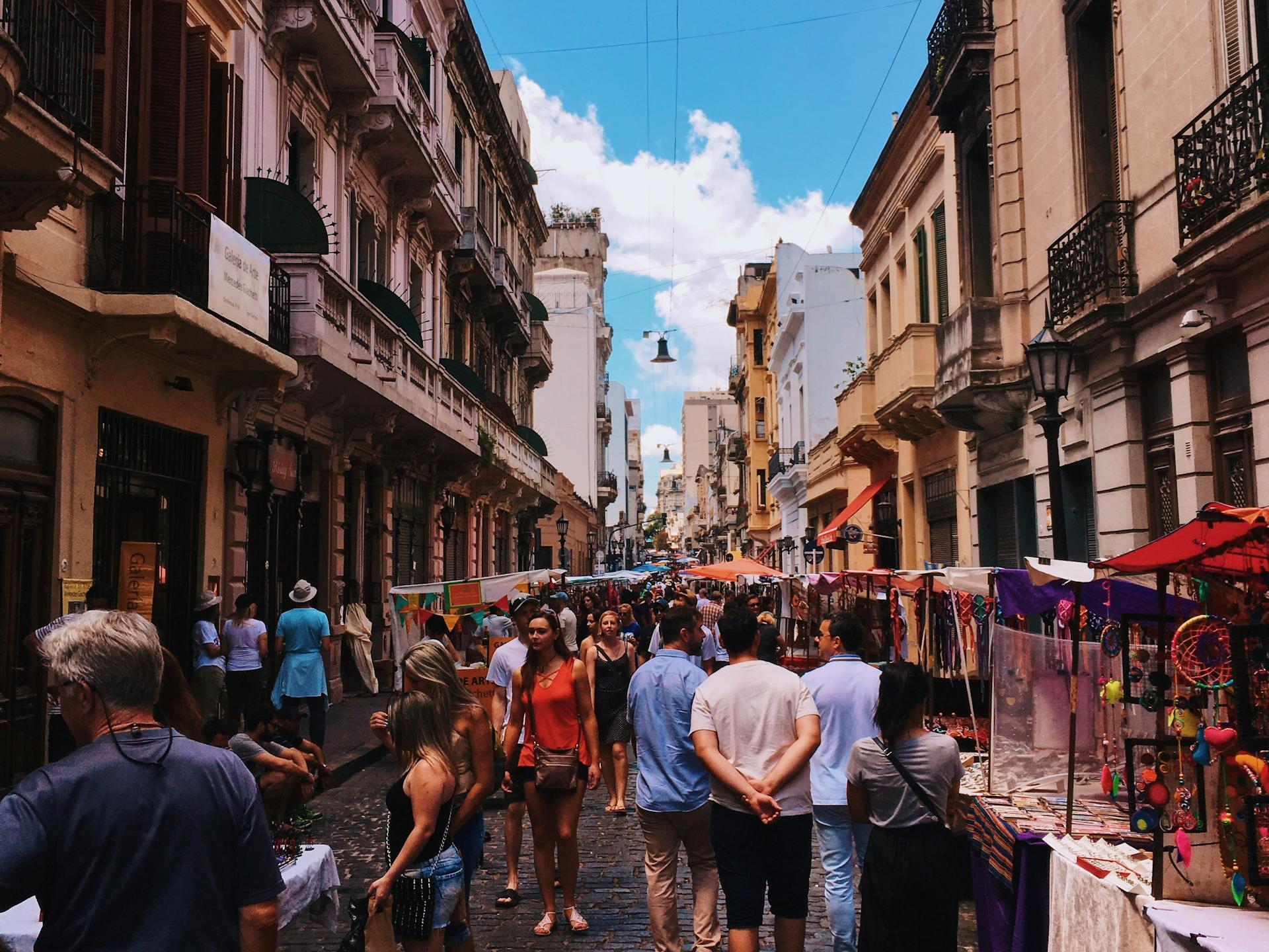 Feria entre las calles de la ciudad con mucha gente. 
