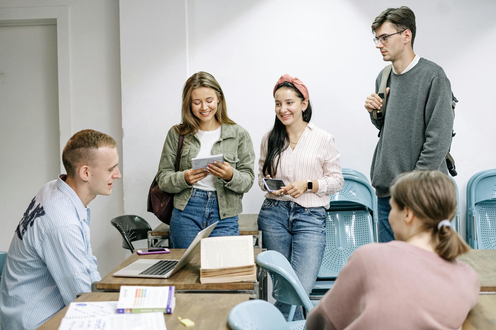 Grupo de jóvenes conversando alrededor del escritorio.
