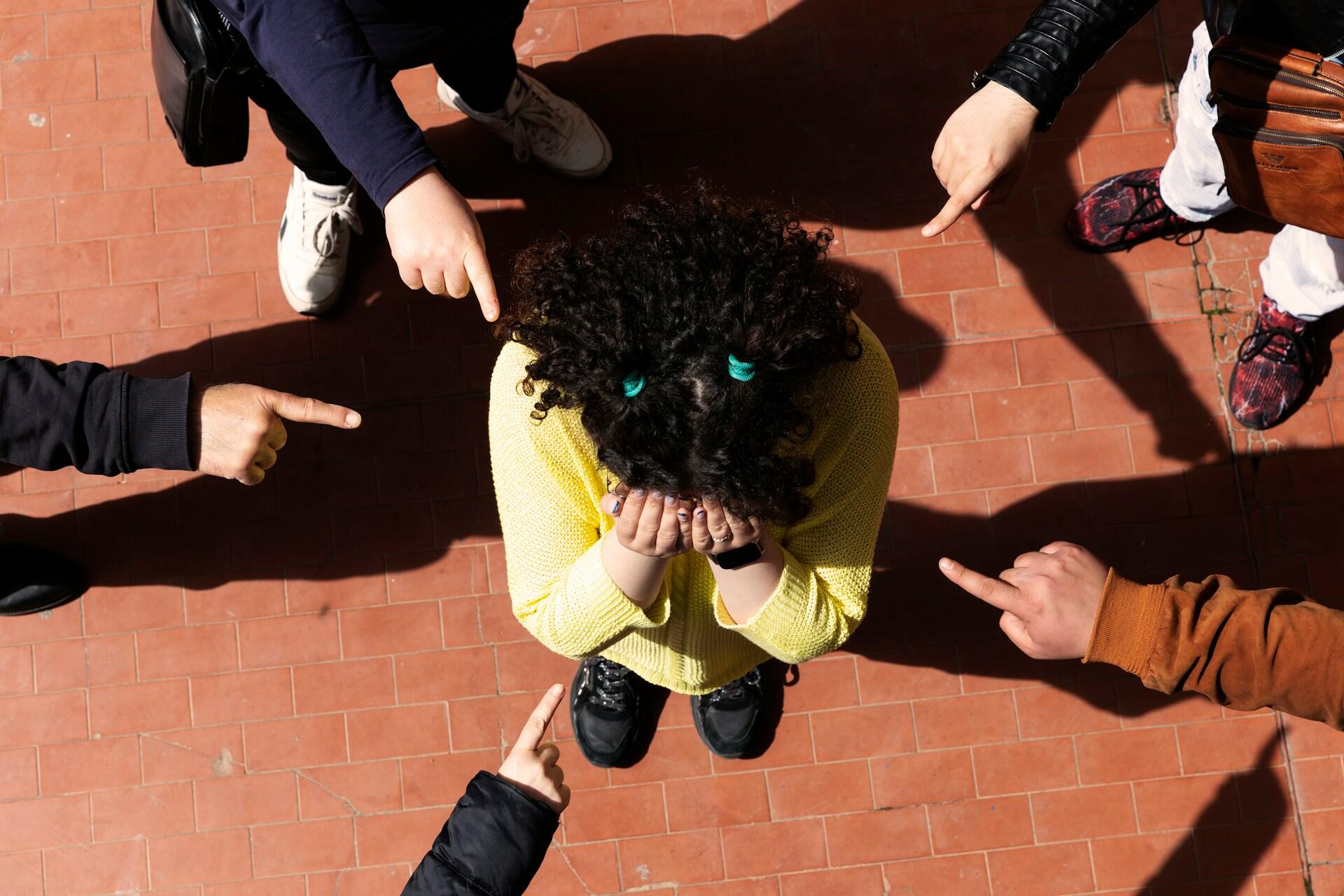 Ronda de niños apuntando a una niña