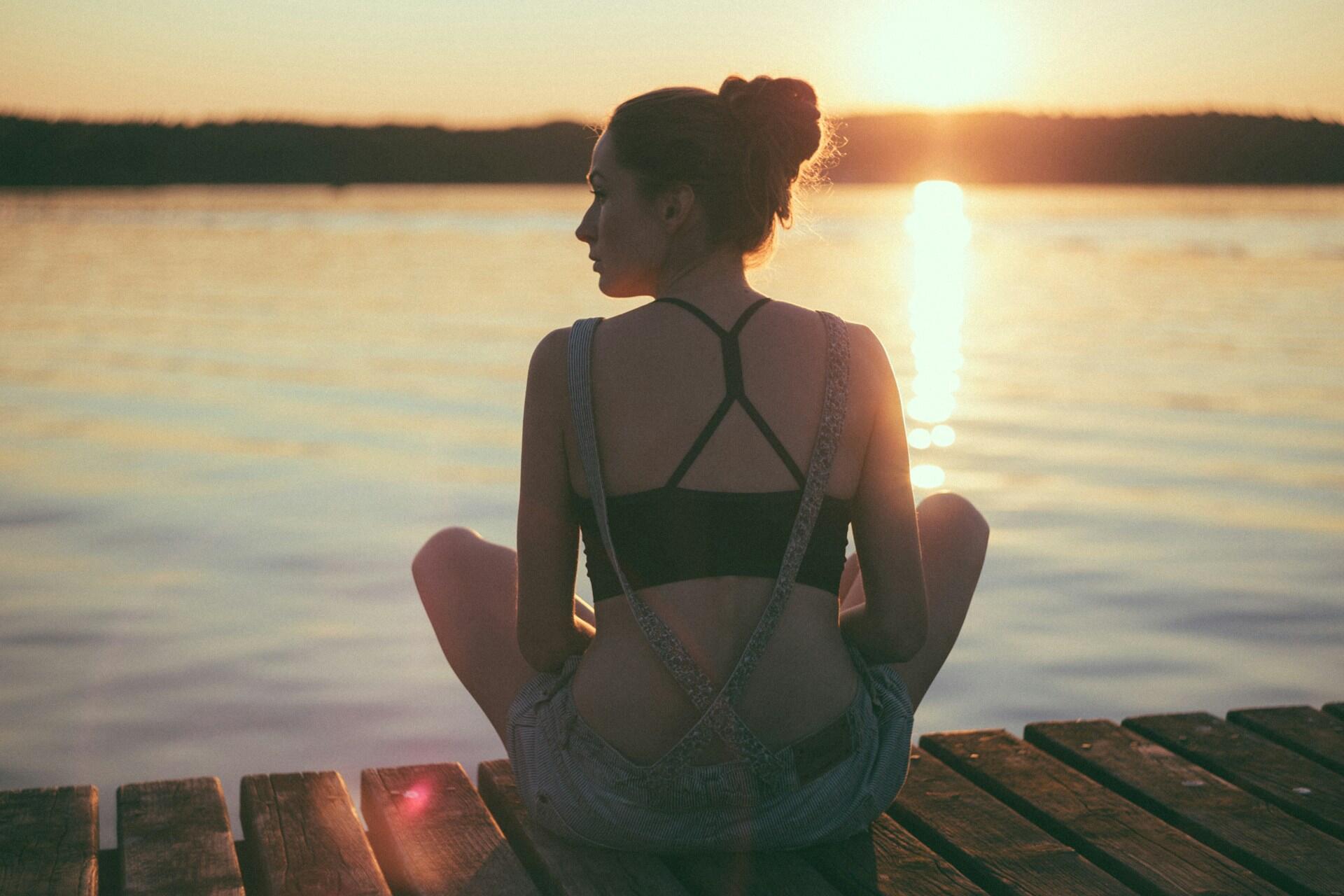 Mujer meditando frente a un río
