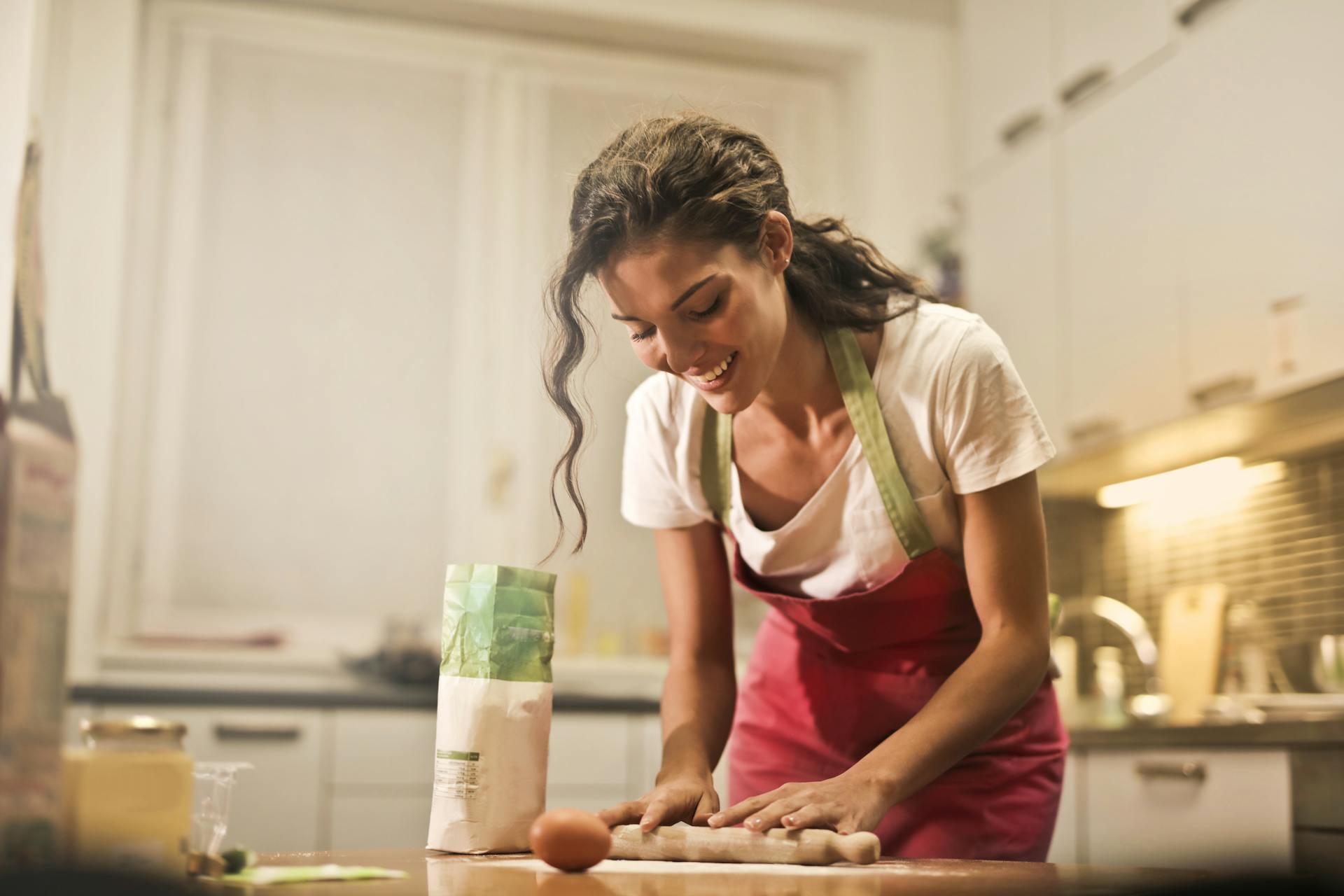 Mujer feliz cocinando en casa.
