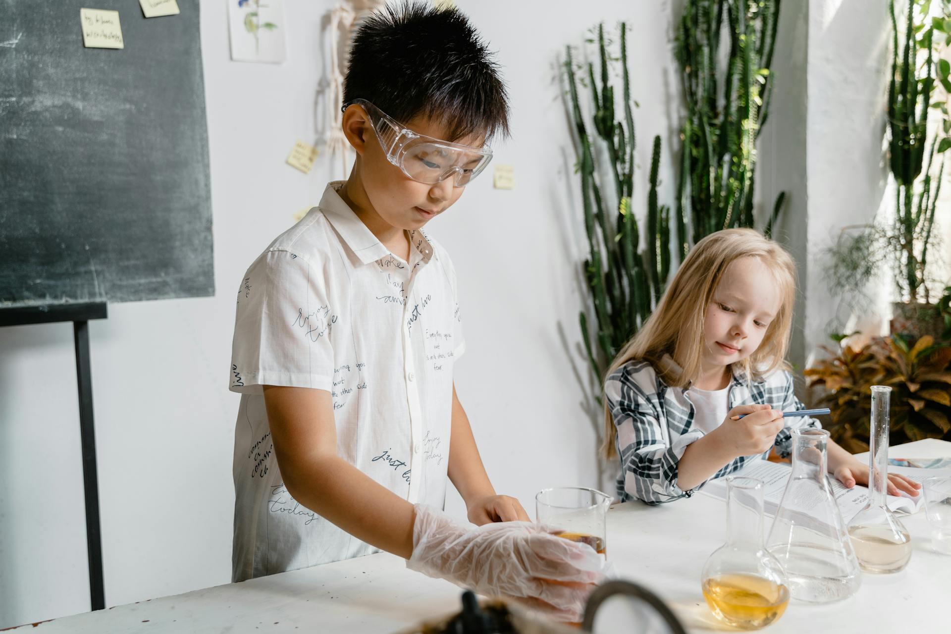Una niña y un niño con frascos sobre la mesa.