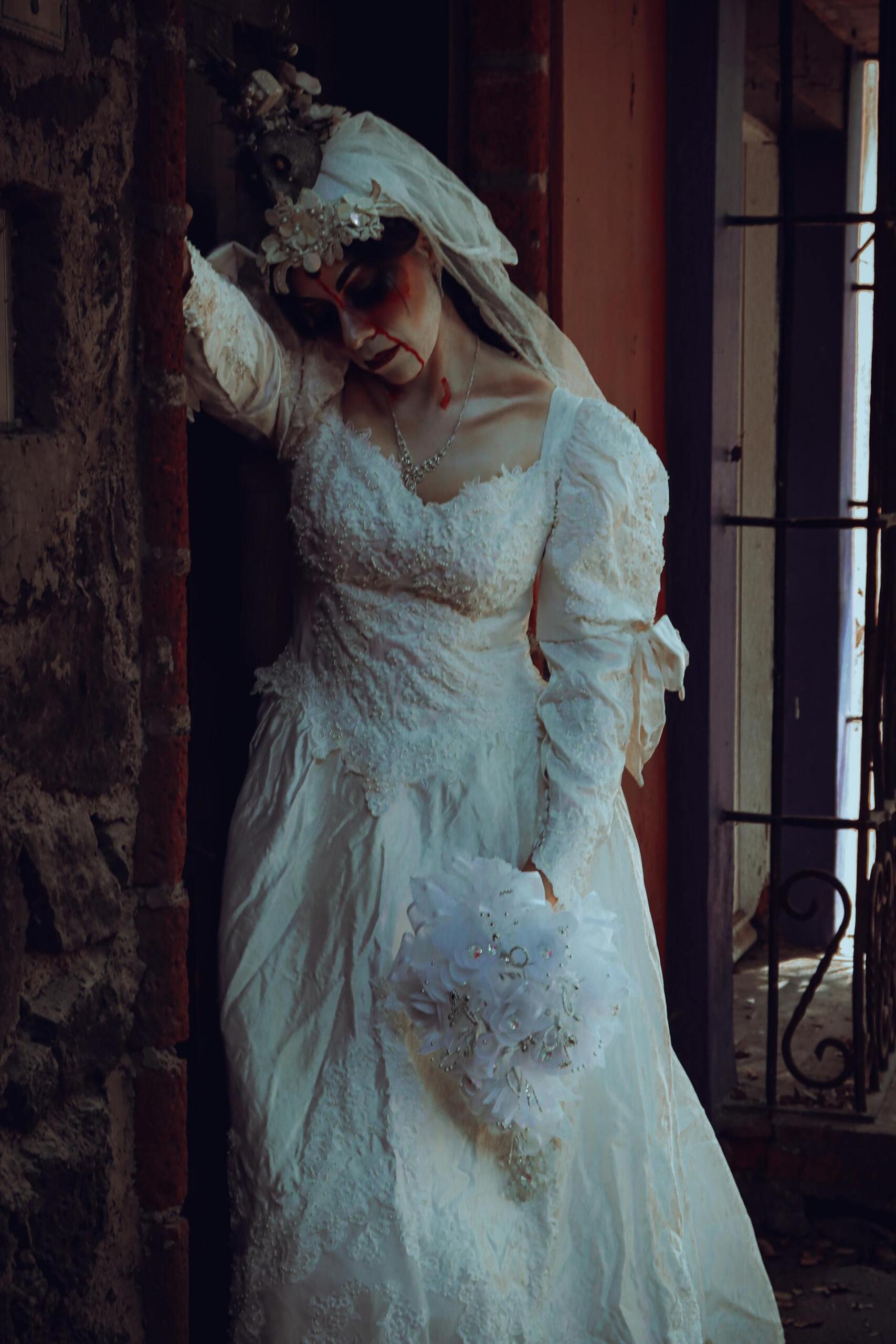 Mujer con vestido blanco, velo y maquillaje sangriento.