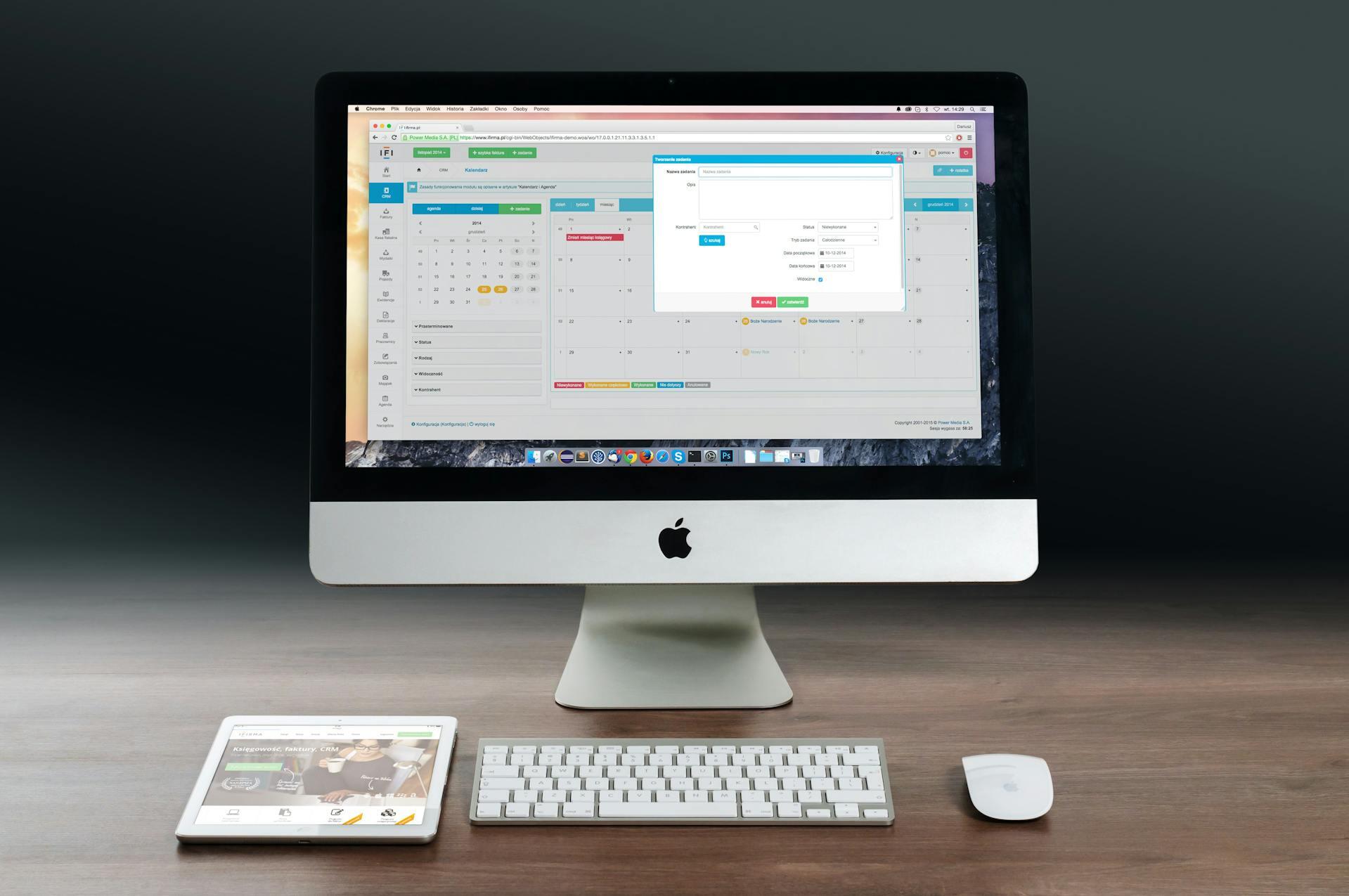 Silver iMac, teclado y mouse sobre superficie de madera.