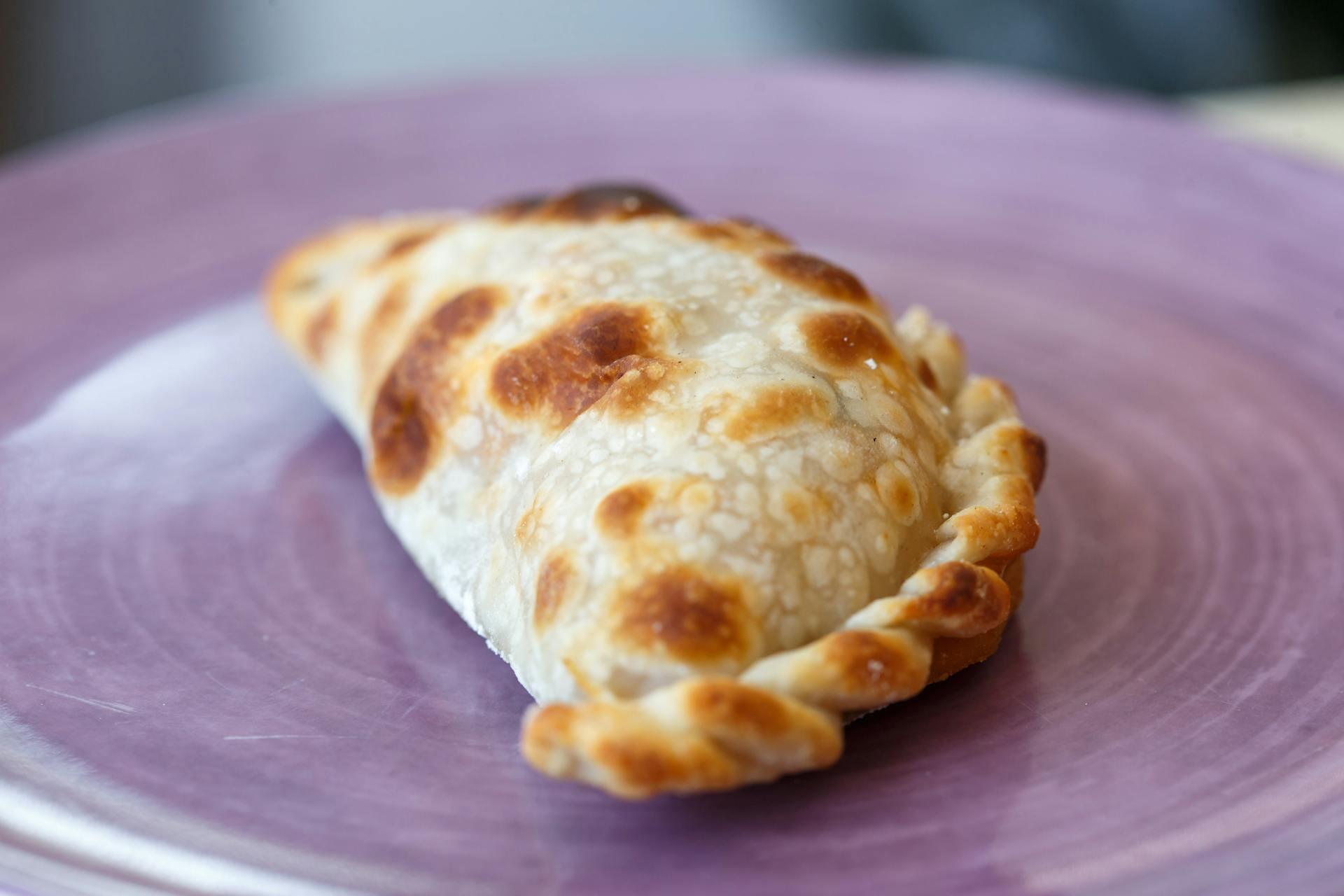 Empanada sobre plato violeta.
