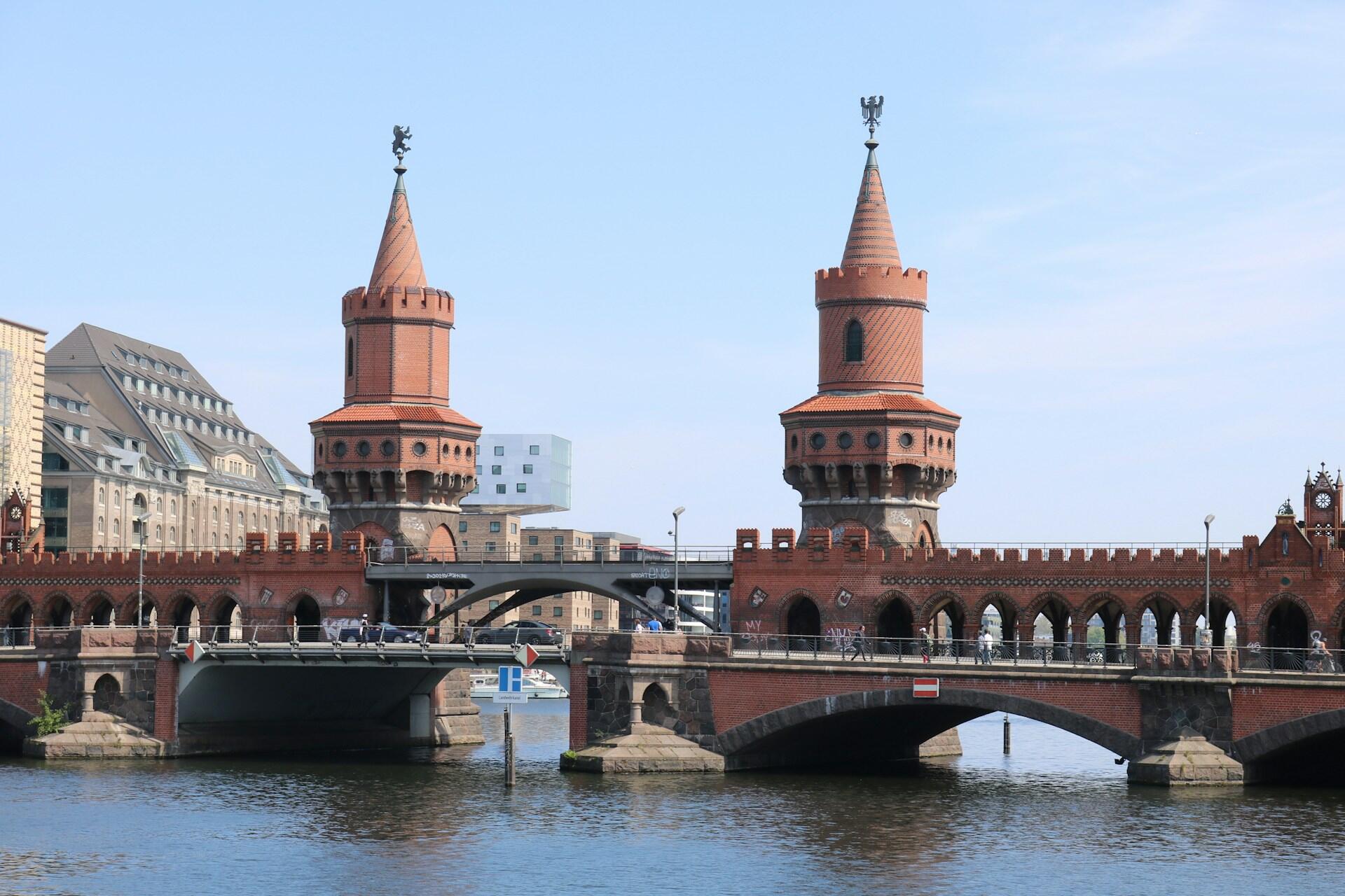 Edificio de ladrillos con cúpulas sobre el puente arriba del agua.