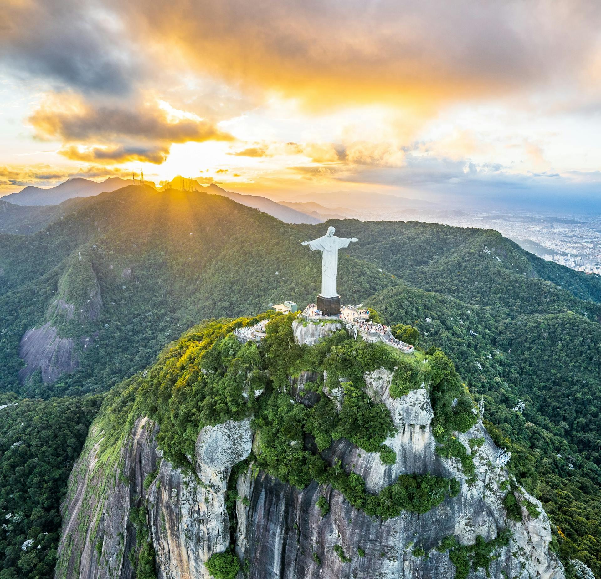 Estatua blanca sobre la montaña de roca y pasto.