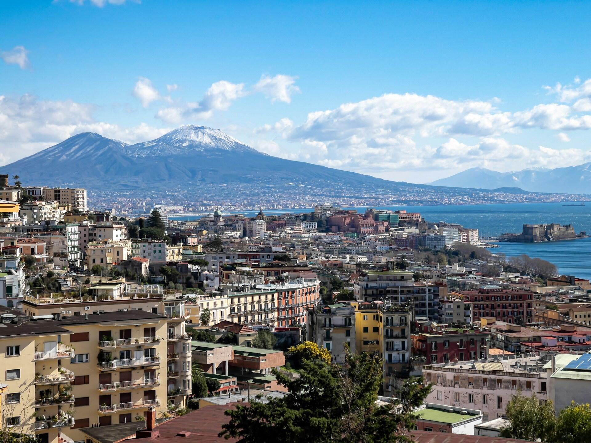 Vista de una ciudad con mar y montañas al fondo. Fuente: Aversa Taxi