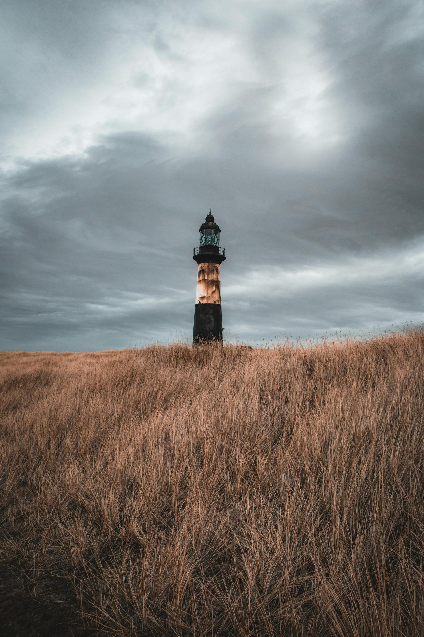 Faro solitario en las afueras de Stanley, Islas Malvinas. La imagen representa el paisaje ventoso y aislado del "Camp", con el faro rodeado de pastizales secos. Fotografía de Klajdi Cena.