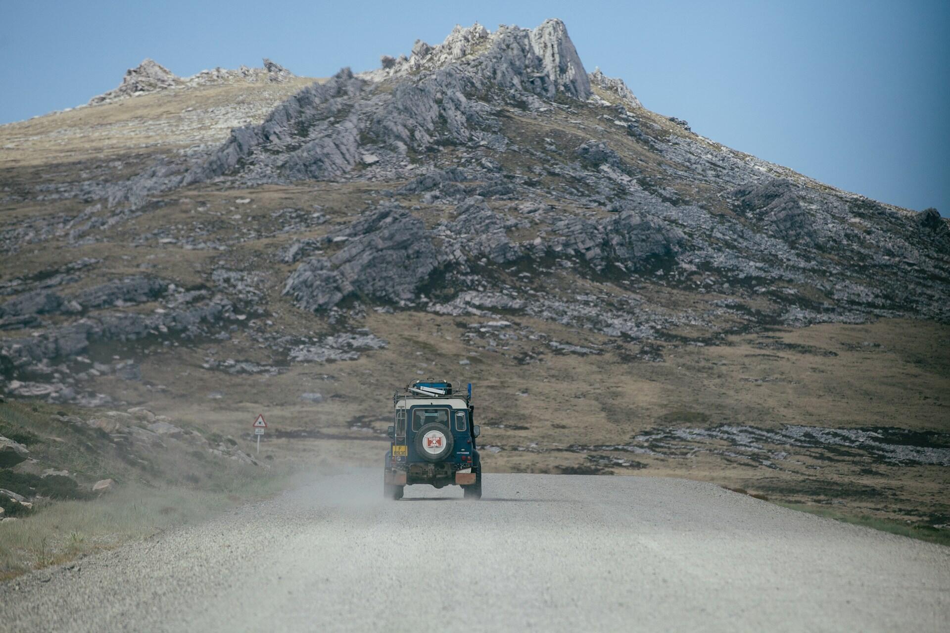 Vehículo 4x4 en un camino rural de las Islas Malvinas. La imagen muestra un Land Rover avanzando por el paisaje rocoso y agreste del "Camp". Fotografía de Yuriy Rzhemovskiy.