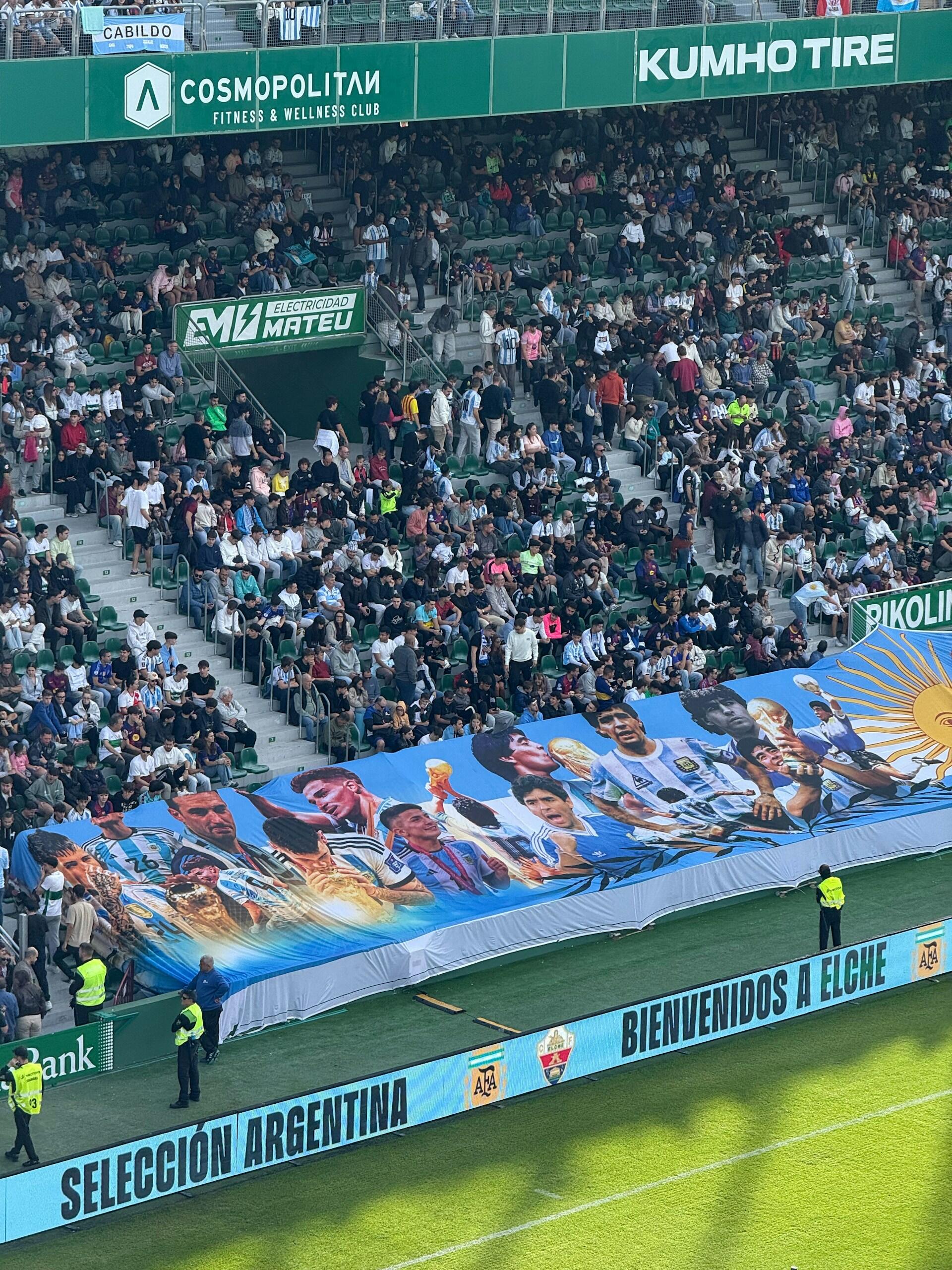 Elche, España. Una bandera gigante con los campeones del mundo de la Selección Argentina desplegada en la tribuna de un estadio. Fotografía de Luciano Prats.