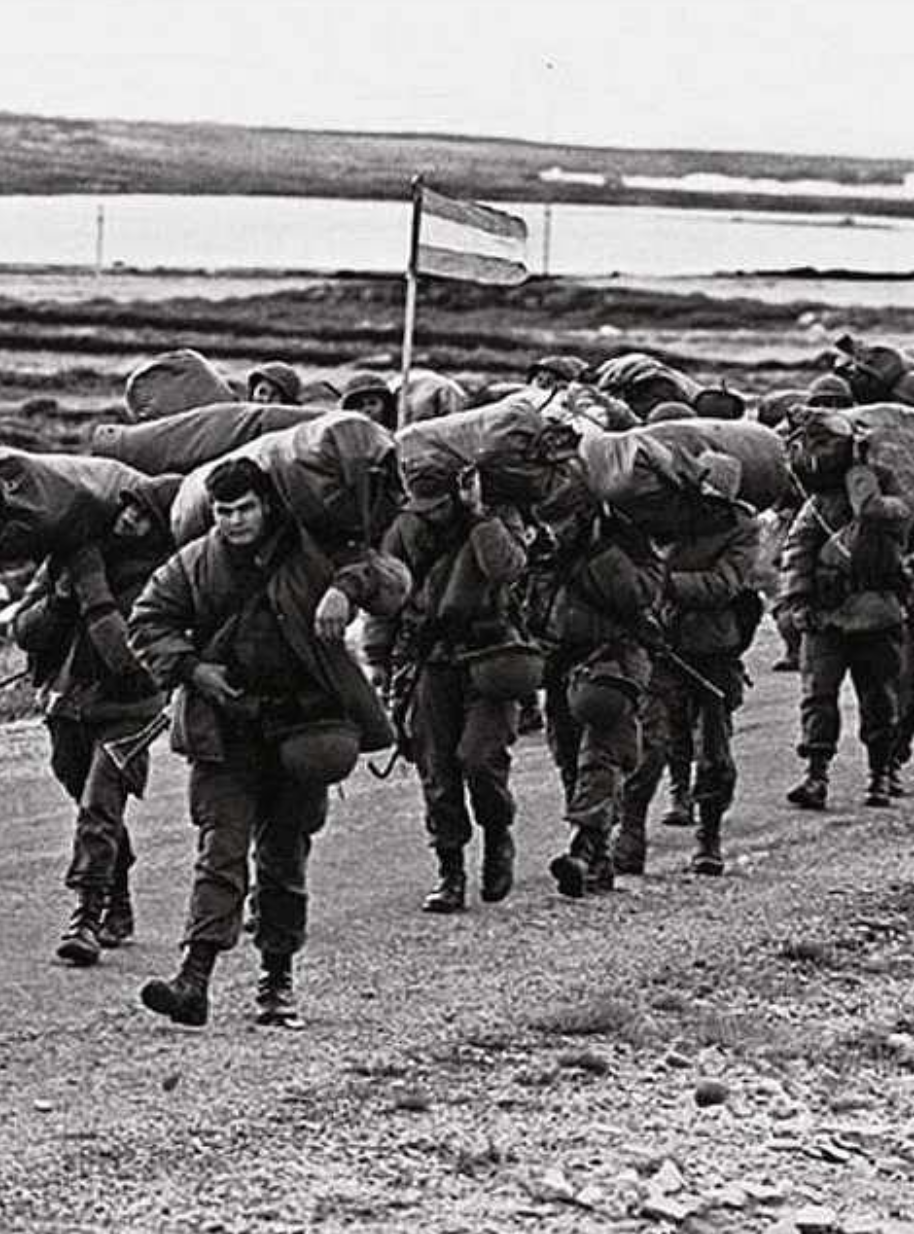 Soldados argentinos marchando con equipamiento en las Islas Malvinas durante la guerra de 1982. Fuente: PICRYL / GetArchive, dominio público.