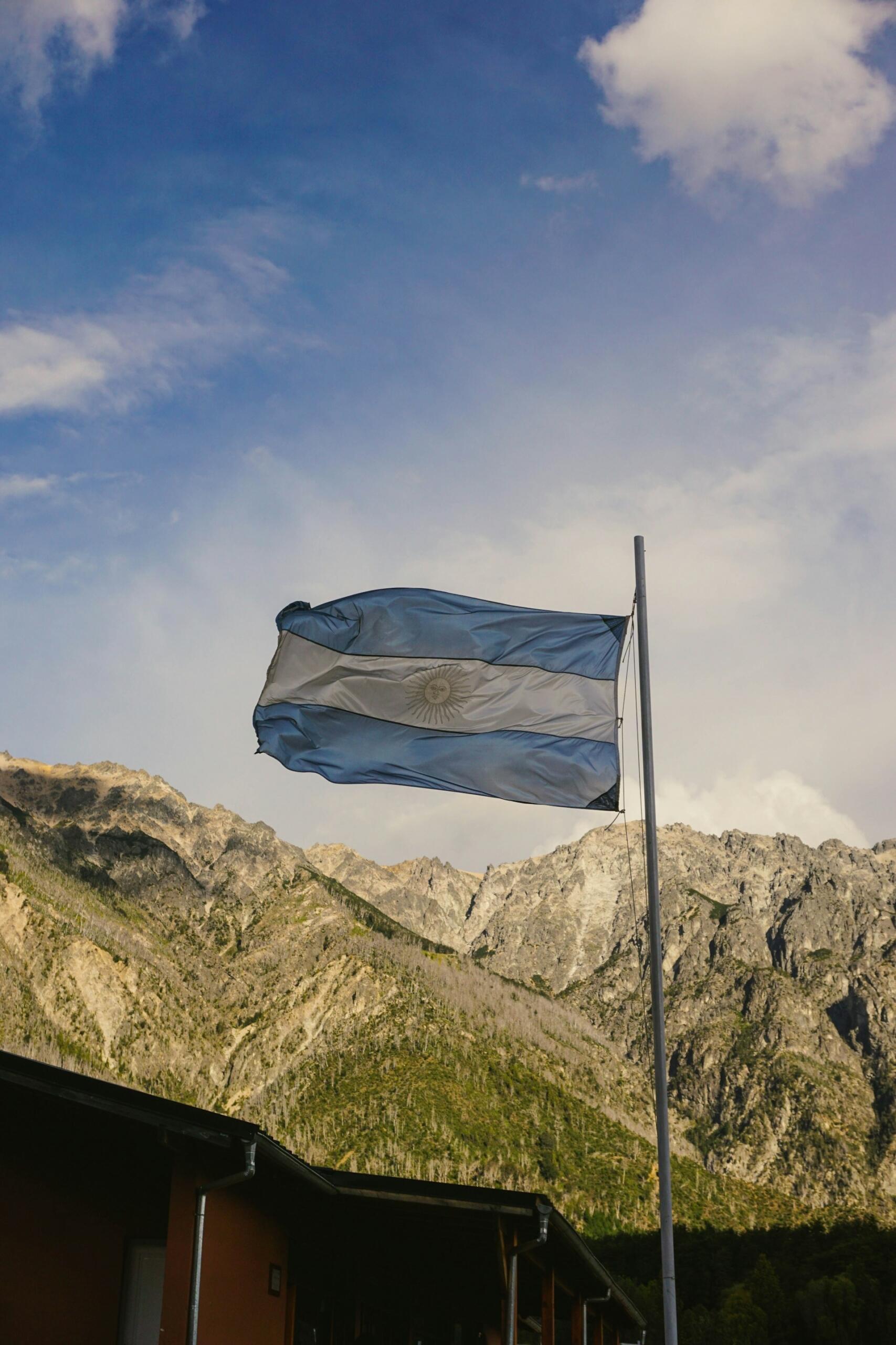 Bandera argentina flameando frente a las montañas de la Patagonia, simbolizando el potencial del país como exportador de energía. Fotografía de Camila Seves Espasandin.
