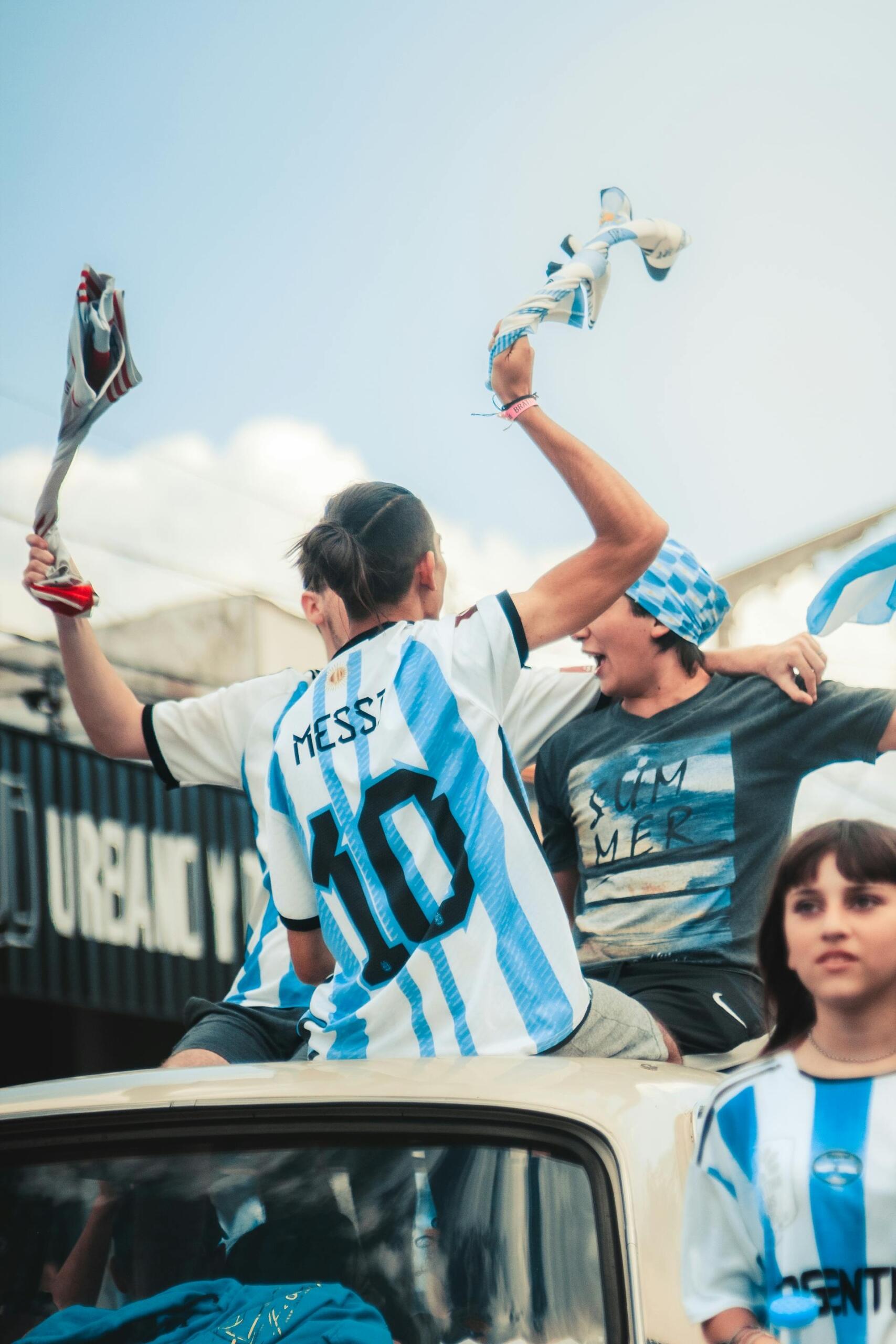 Festejos en Argentina: un joven con la camiseta 10 de Messi celebra enérgicamente sobre el techo de un auto. Foto por KOVAC.lay.
