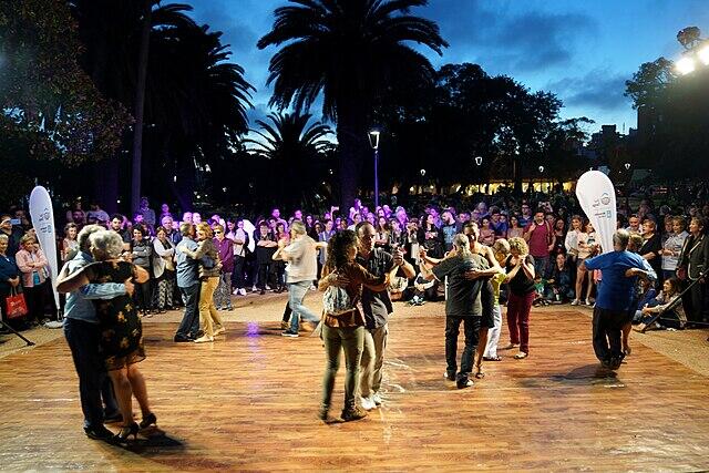 Gente bailando en la plaza.