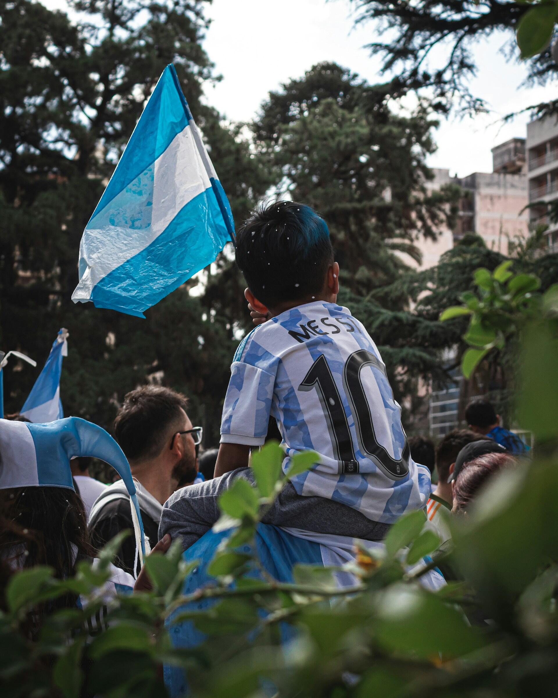 Calles de Argentina: un niño sobre hombros con la camiseta 10 de Messi y una bandera argentina durante los festejos populares. Foto por Pedro Chosco.