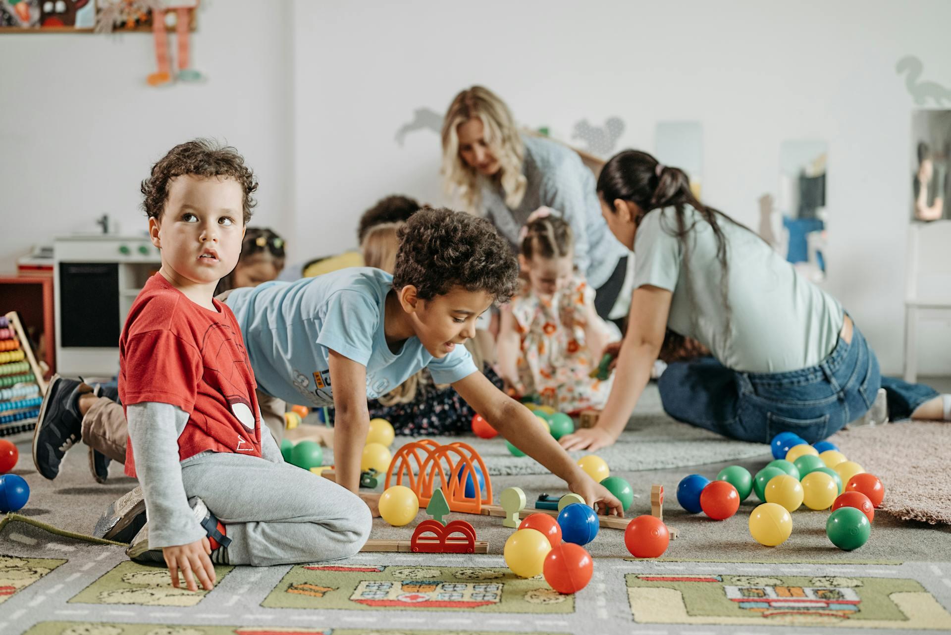 Niños jugando sobre la alfombra.